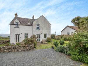a large white house with a stone wall at Jura in Drummore