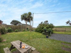 a picnic table with a bottle of wine on it at Jura in Drummore