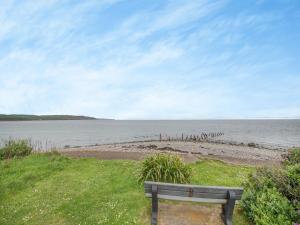 a bench sitting on the grass near a body of water at Jura in Drummore +12 photos