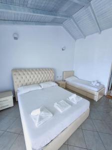 a bedroom with a large white bed with white sheets at Sunrise Dhermi Beach in Dhërmi