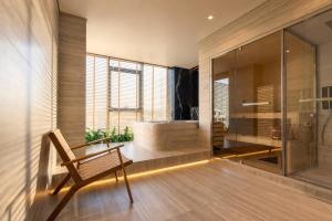 a bathroom with a soaking tub and a wooden bench at OPUS Batumi in Batumi