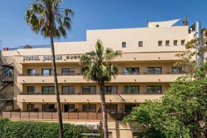 a building with palm trees in front of it at Hotel Delfín 4 Sup in Tossa de Mar