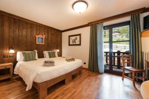 a bedroom with a bed and a large window at Silou Retreat in Champdepraz +41 photos