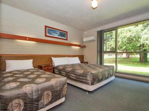 Bright Motor Inn tesisinde bir odada yatak veya yataklar