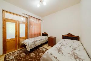 a bedroom with two beds and a door at NNN Guest House in Goris