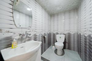 a white bathroom with a sink and a toilet at NNN Guest House in Goris +91 photos