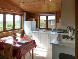 a kitchen with a table and a kitchen with white appliances at Wren Lodge - E5023 in Nawton