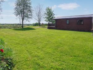 a large yard next to a building with a grass field at Wren Lodge - E5023 in Nawton