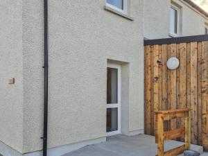a house with a wooden fence next to it at Husabost House in Carinish +11 photos