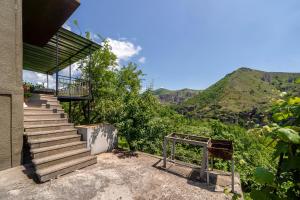 a set of stairs leading up to a house with mountains in the background at NNN Guest House in Goris