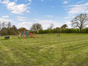 an empty field with two playground equipment in a field at The Barbon - Uk47033 in Kirkby Lonsdale