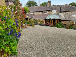 a garden with flowers in front of a building at Little Forda in Chillaton