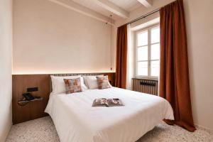 a bedroom with a bed with a book on it at Resort Casa del Monte 1553 in Albenga