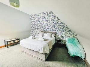 a bedroom with a bed with a floral accent wall at Stronvaar in Stranraer