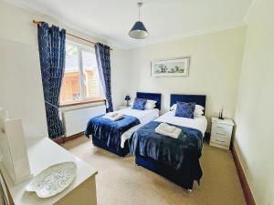 a bedroom with two beds and a window at Stronvaar in Stranraer