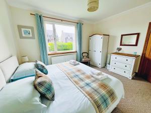 a bedroom with a large bed and a window at Stronvaar in Stranraer +12 photos