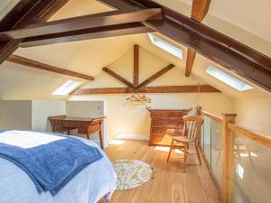 a bedroom with a bed and a desk in a attic at The Old Stable in Dursley