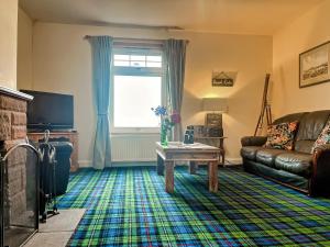 a living room with a couch and a table at Gigha in Drummore +8 photos