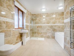 a bathroom with a toilet and a sink and a tub at Hawthorn Lodge - Uk42546 in Llanwrthwl