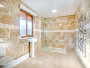 a bathroom with a toilet and a sink at Hawthorn Lodge - Uk42546 in Llanwrthwl
