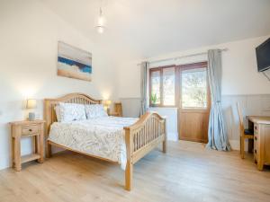 a bedroom with a wooden bed and a window at Hawthorn Lodge - Uk42546 in Llanwrthwl +14 photos