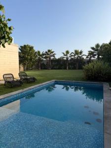 a swimming pool in a yard with two benches at Casa Catalina - Oceanfront house Lima in Lima