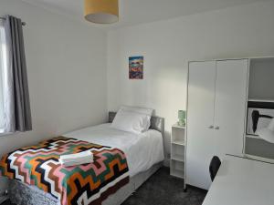 a small bedroom with a bed and a cabinet at private room with shared bathroom 20 minutes walk to Durham centre in Gilesgate