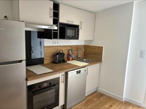 a small kitchen with white cabinets and a sink at chez ophélia in Sainte-Tulle