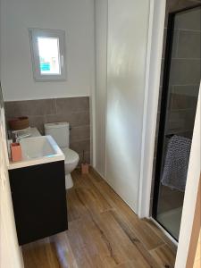 a bathroom with a white toilet and a sink at chez ophélia in Sainte-Tulle