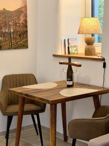 a wooden table with a bottle of wine on it at Gimmeldinger Haus in Neustadt an der Weinstraße