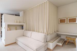 a living room with a white couch and a table at Refúgio Do Loureiro in Sesimbra