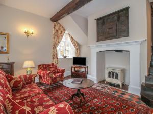 a living room with a couch and a fireplace at The Butlers Quarters in Much Wenlock