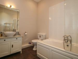 a bathroom with a tub and a toilet and a sink at The Butlers Quarters in Much Wenlock +22 photos