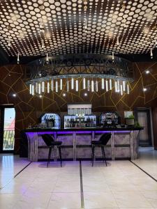 a bar in a room with chairs and lights at Royal Hotel Navoi in Navoi