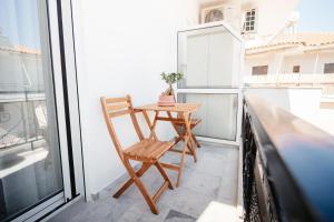 a wooden chair sitting on a balcony with a table at Aida's Apartment Nafplio in Nafplio