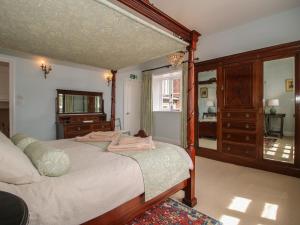 a bedroom with a bed and a dresser and a mirror at The Butlers Quarters in Much Wenlock
