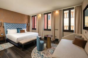 a hotel room with a bed and a couch at The Venice Times Hotel, Vignette Collection by IHG in Venice