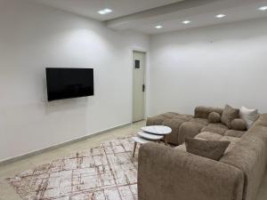 a living room with a couch and a flat screen tv at Appartement El-Chahed in Annaba