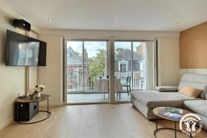 a living room with a couch and a view of a balcony at Ker helios in Dinard