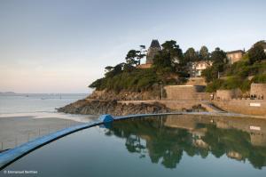 a bridge over the water next to a beach at Ker helios in Dinard