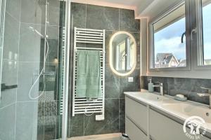a bathroom with a shower and a sink and a mirror at Ker helios in Dinard +24 photos