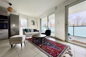 a living room with a couch and a table and chairs at The Ill in Softness calm & elegant in Illkirch-Graffenstaden