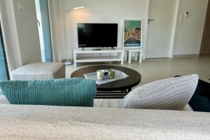 a living room with a tv and a table and chairs at The Ill in Softness calm & elegant in Illkirch-Graffenstaden