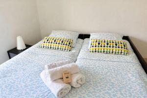 a bedroom with two beds with towels and pillows at The Ill in Softness calm & elegant in Illkirch-Graffenstaden
