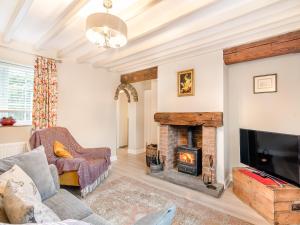 a living room with a fireplace and a tv at Craven Bungalow in Allerston