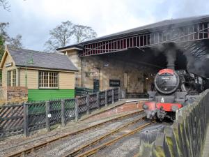 a steam engine train pulling into a train station at Craven Bungalow in Allerston