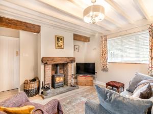 a living room with a fireplace and a tv at Craven Bungalow in Allerston