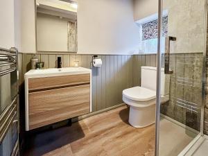 a bathroom with a toilet and a sink at Craven Bungalow in Allerston +4 photos