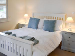 a white bed with blue pillows in a bedroom at Percy's Place in Alnwick