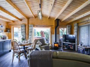 a living room with a couch and a tv at Stable Lodge At Greenacre in Bromyard +12 photos